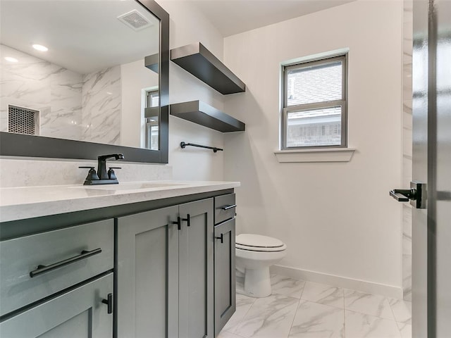 bathroom with visible vents, toilet, marble finish floor, baseboards, and vanity