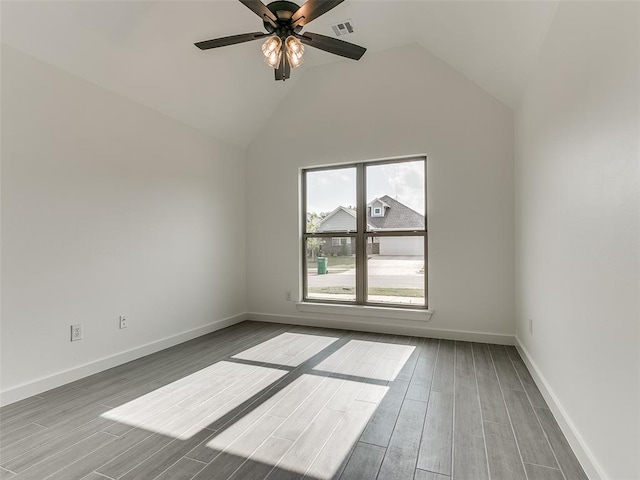 empty room featuring visible vents, baseboards, wood tiled floor, high vaulted ceiling, and a ceiling fan