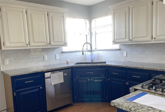 kitchen featuring dishwasher, white cabinets, blue cabinets, and a sink