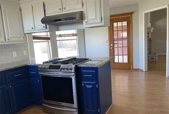 kitchen featuring a peninsula, blue cabinetry, stainless steel range with gas stovetop, under cabinet range hood, and white cabinetry