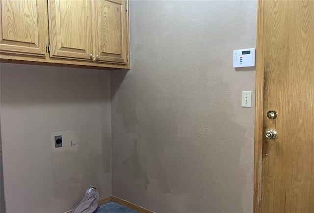 washroom with cabinet space, electric dryer hookup, baseboards, and a textured wall