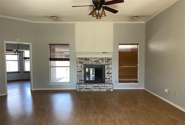 unfurnished living room featuring dark wood-style floors, a wealth of natural light, crown molding, and ceiling fan