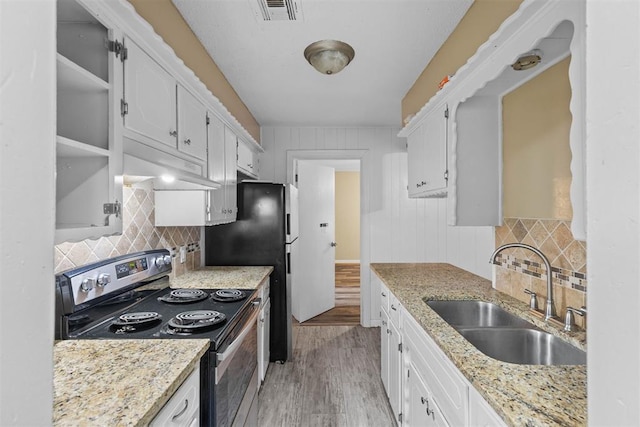 kitchen featuring visible vents, under cabinet range hood, stainless steel range with electric cooktop, white cabinetry, and a sink