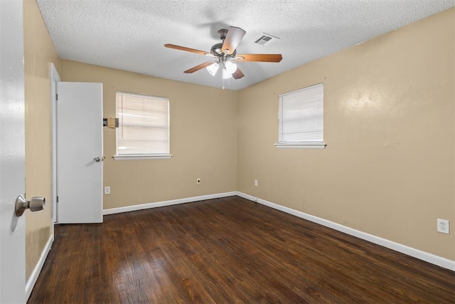 unfurnished room featuring hardwood / wood-style flooring, visible vents, baseboards, and ceiling fan