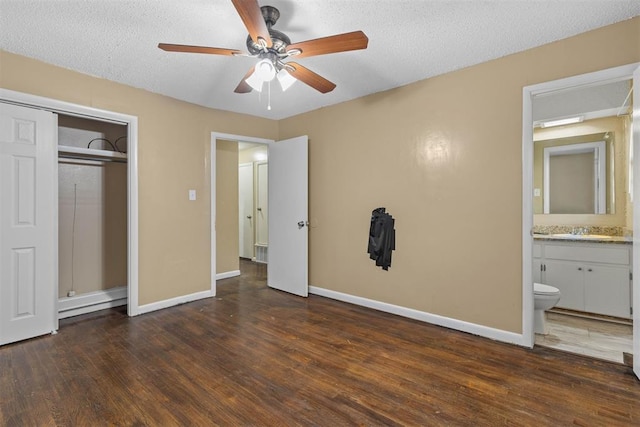 unfurnished bedroom with wood finished floors, baseboards, a closet, and a sink