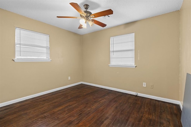 spare room with wood finished floors, a ceiling fan, and baseboards