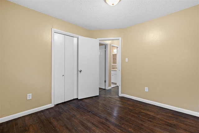 unfurnished bedroom with a textured ceiling, baseboards, and wood finished floors