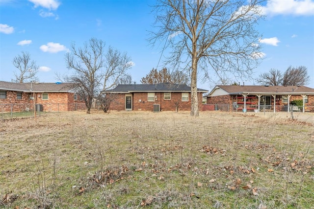 rear view of property with brick siding and fence