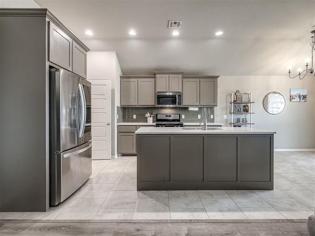 kitchen with visible vents, a sink, gray cabinetry, light countertops, and appliances with stainless steel finishes