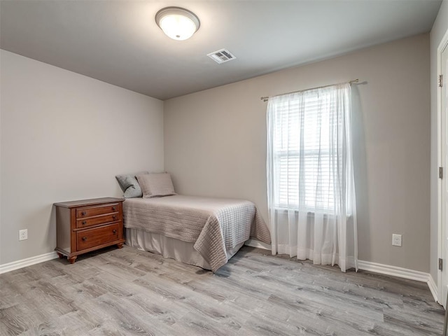 bedroom featuring baseboards, visible vents, and light wood-type flooring