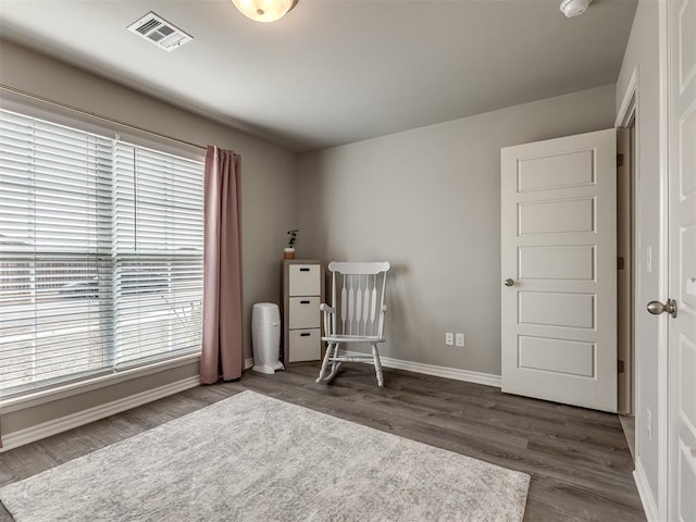 interior space with plenty of natural light, dark wood-style floors, visible vents, and baseboards