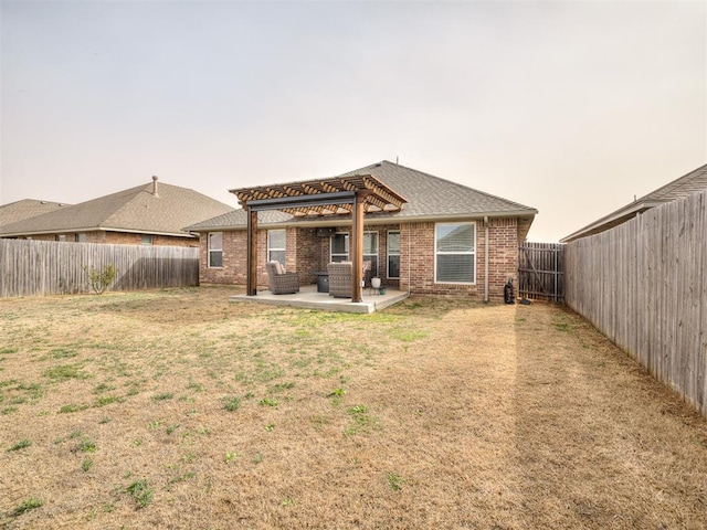 back of house with brick siding, a fenced backyard, a yard, a pergola, and a patio