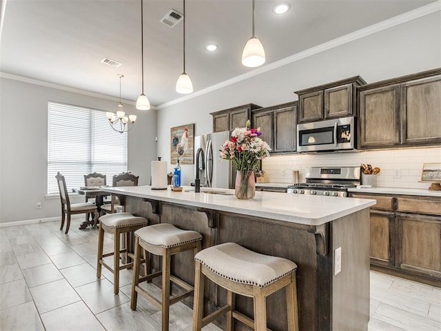 kitchen featuring stainless steel appliances, visible vents, ornamental molding, and decorative backsplash