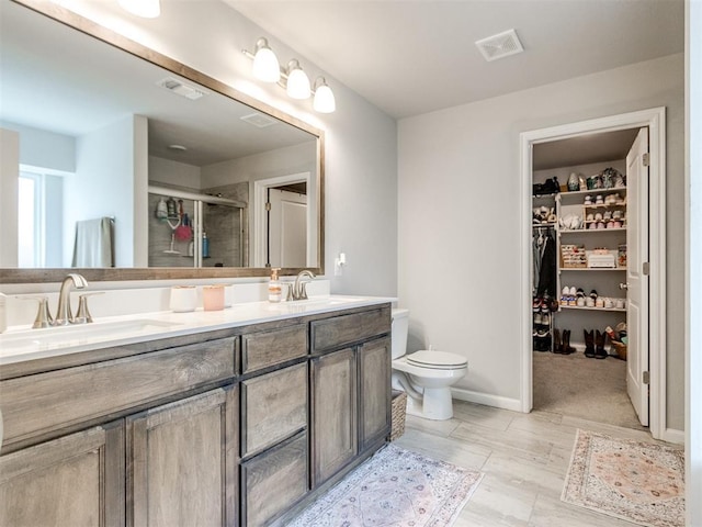 full bathroom with double vanity, visible vents, a stall shower, and a sink