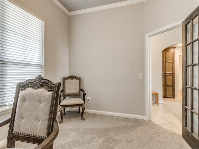 living area featuring baseboards, arched walkways, carpet, and ornamental molding