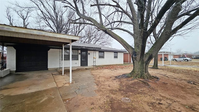 ranch-style home with an attached carport, a garage, and driveway