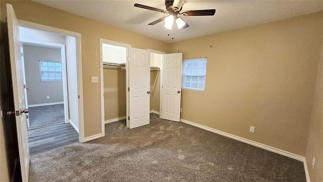 unfurnished bedroom featuring a closet, baseboards, a ceiling fan, and dark carpet