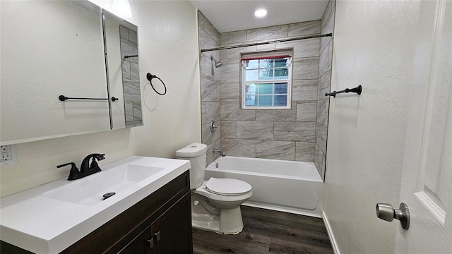 bathroom with vanity, wood finished floors, baseboards, bathtub / shower combination, and toilet