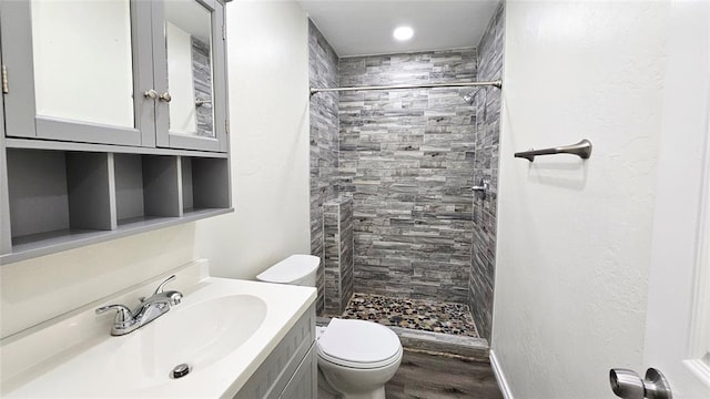 bathroom with vanity, toilet, wood finished floors, and a shower stall