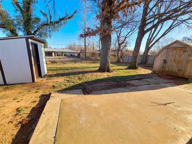 view of yard featuring a shed, an outdoor structure, and fence