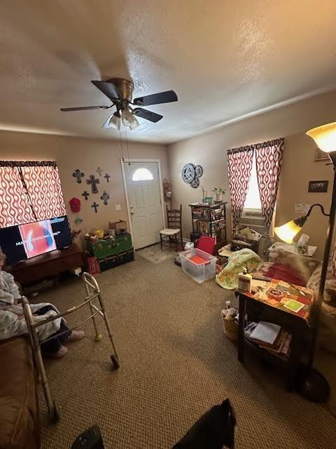 carpeted living area featuring a ceiling fan