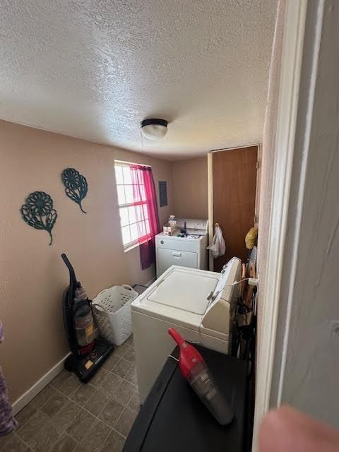 laundry room featuring independent washer and dryer, a textured ceiling, and baseboards