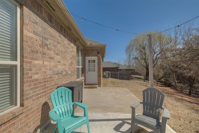 view of patio with central air condition unit and fence