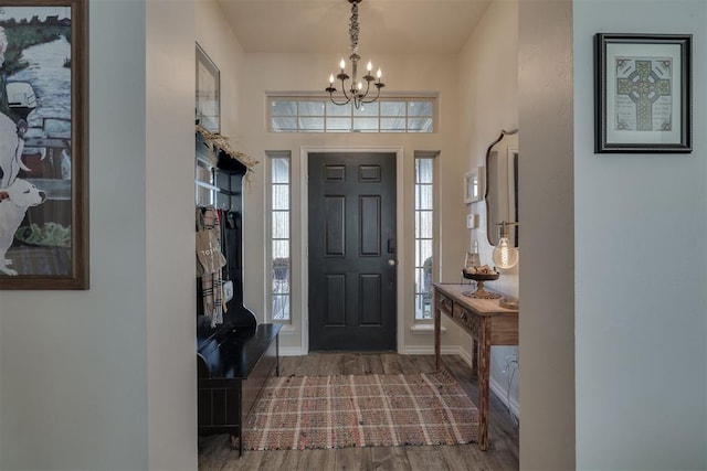 foyer with a chandelier, baseboards, and wood finished floors