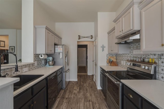 kitchen with under cabinet range hood, stainless steel appliances, light countertops, and a sink