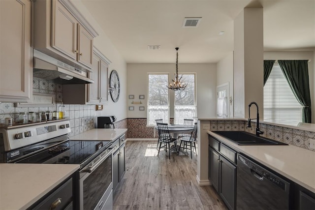 kitchen with stainless steel electric range oven, visible vents, a sink, under cabinet range hood, and dishwasher