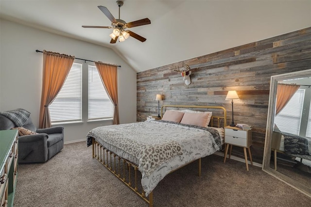 carpeted bedroom featuring vaulted ceiling, baseboards, wood walls, and ceiling fan