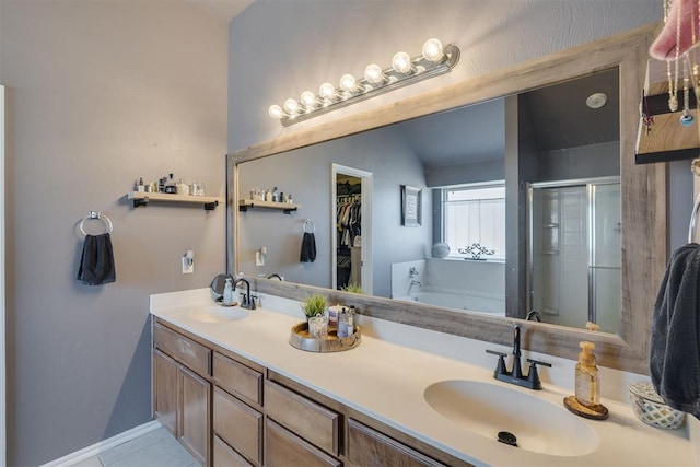 full bathroom featuring double vanity, a stall shower, a garden tub, and a sink