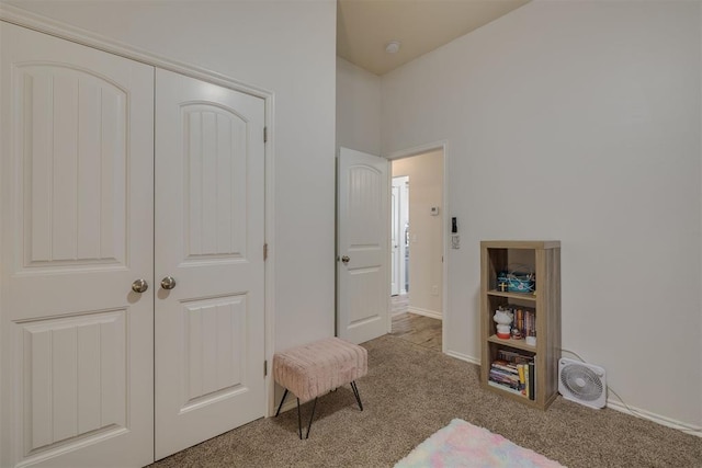 carpeted bedroom with a closet and baseboards