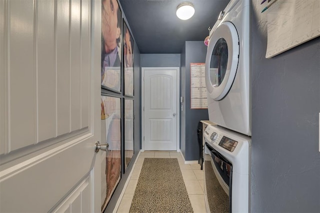 laundry area with light tile patterned floors, laundry area, and stacked washer and clothes dryer