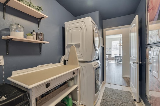 washroom featuring laundry area, stacked washer / dryer, and light tile patterned flooring