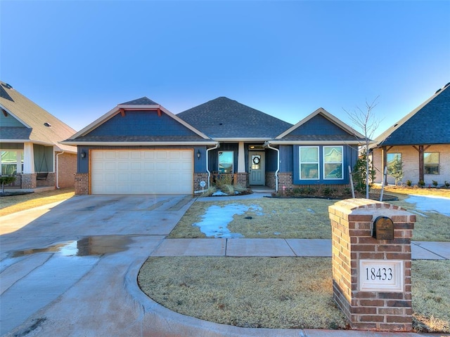 view of front of home with concrete driveway, a garage, brick siding, and roof with shingles