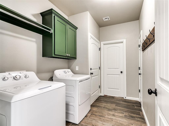 clothes washing area featuring visible vents, baseboards, wood tiled floor, cabinet space, and independent washer and dryer