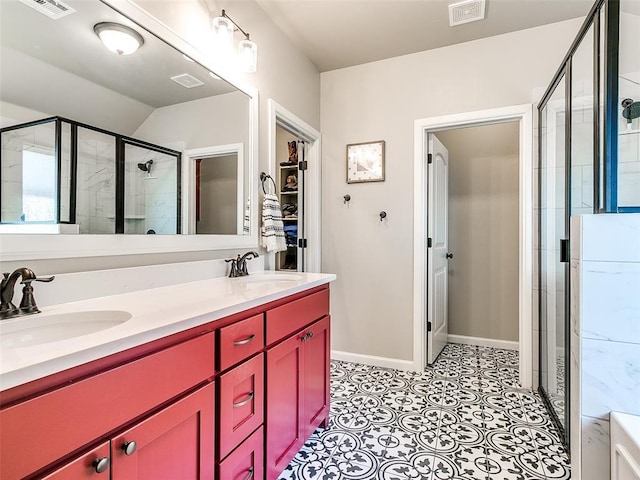 bathroom featuring a shower stall, double vanity, visible vents, and a sink