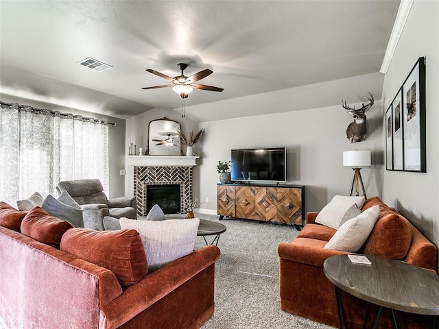 living area featuring visible vents, a ceiling fan, carpet floors, vaulted ceiling, and a tile fireplace