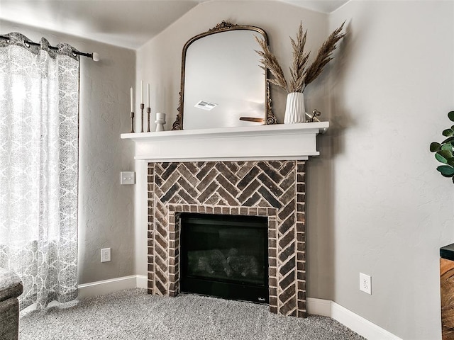 interior details featuring baseboards, visible vents, carpet floors, a brick fireplace, and a textured wall