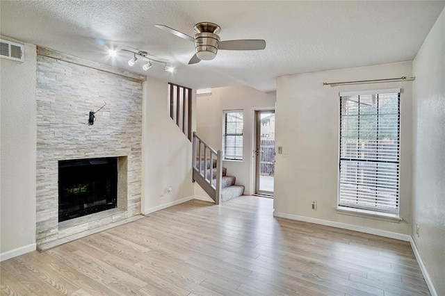 unfurnished living room with a healthy amount of sunlight, wood finished floors, and ceiling fan