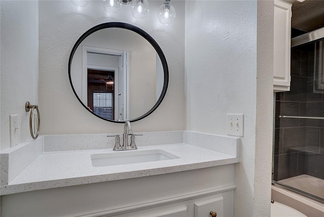 bathroom featuring enclosed tub / shower combo and vanity