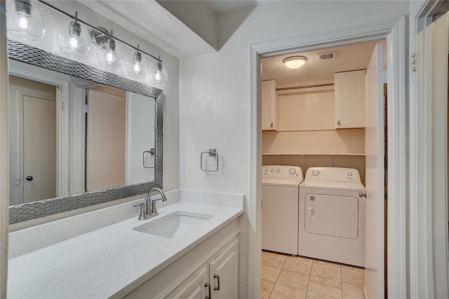 bathroom featuring washing machine and clothes dryer, visible vents, a textured wall, tile patterned floors, and vanity