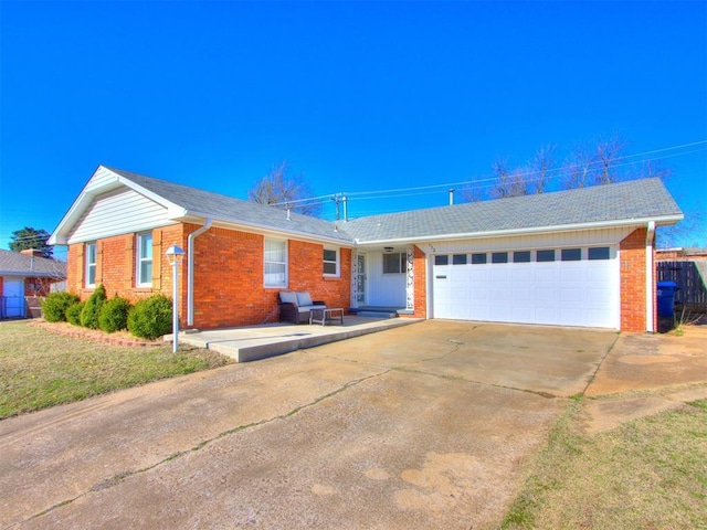 ranch-style house featuring brick siding, an attached garage, driveway, and a front lawn