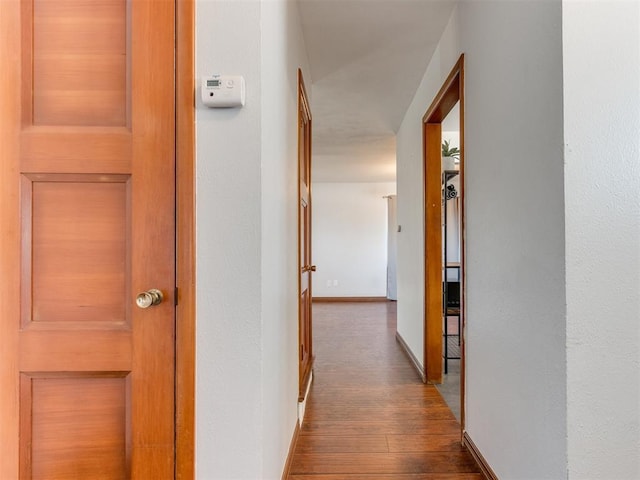 corridor featuring hardwood / wood-style floors and baseboards