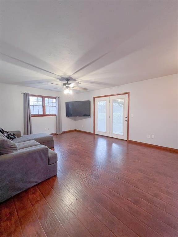 living room with baseboards, beam ceiling, ceiling fan, hardwood / wood-style flooring, and french doors