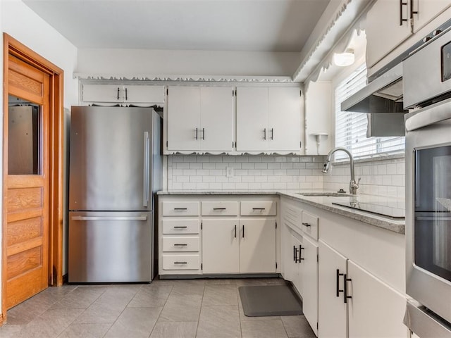 kitchen featuring a sink, tasteful backsplash, appliances with stainless steel finishes, and light tile patterned flooring