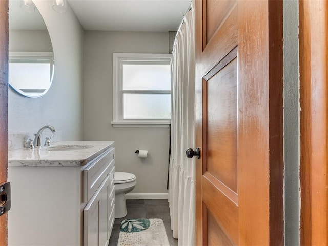 bathroom with vanity, toilet, baseboards, and tile patterned flooring