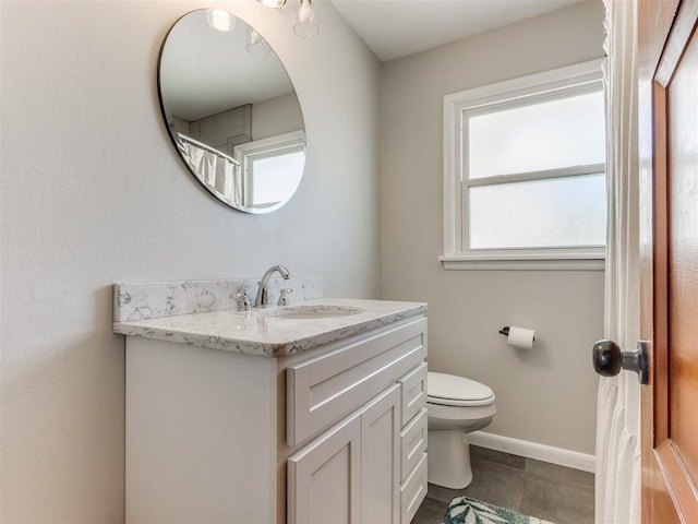 bathroom featuring baseboards, toilet, and vanity