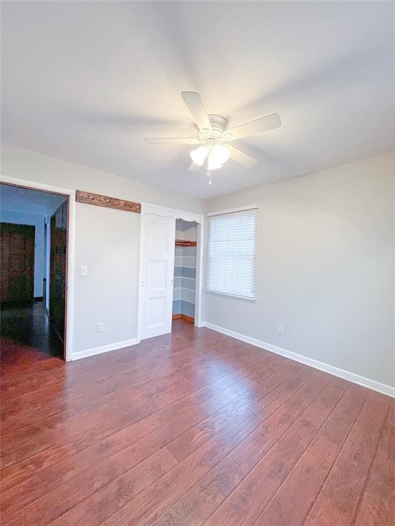 unfurnished bedroom featuring a closet, ceiling fan, baseboards, and wood finished floors